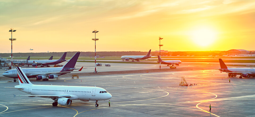 Why flying feels unpredictable in 2026, and what’s actually driving it 2 multiple airplanes on airport tarmac during sunset