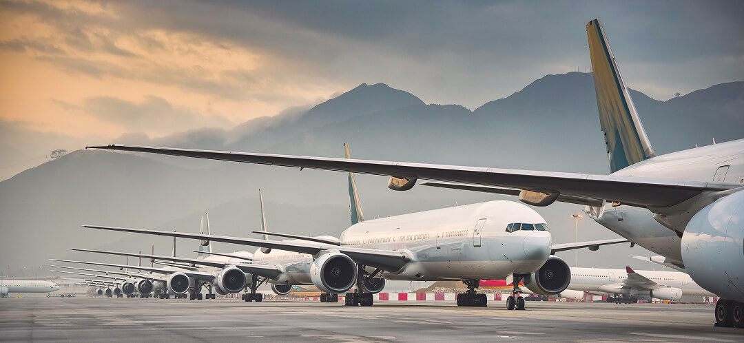Why flying feels unpredictable in 2026, and what’s actually driving it 4 multiple commercial airplanes parked on airport tarmac